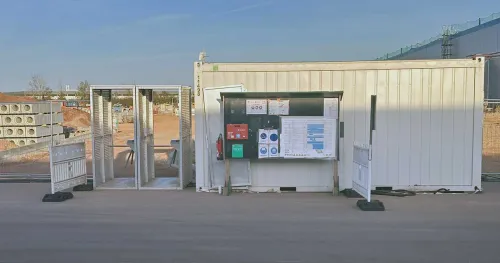 Baustelleneingang mit Zugangskontrollanlage und Container zur Organisation des Personenverkehrs